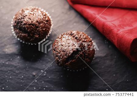 Two chocolate muffins freshly baked at home, homemade comfort food recipe Two chocolate muffins freshly baked at home, homemade comfort food recipe 75377441