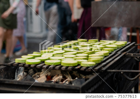 Process of cooking fresh zucchini slices on grill - close up - street food Process of cooking fresh zucchini slices on grill - close up - street food 75377613