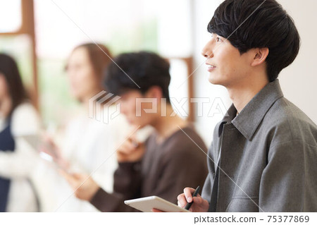 Young man holding a tablet and pen 75377869