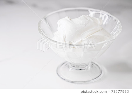 White whipped dessert cream served in a glass bowl, creamy texture 75377953