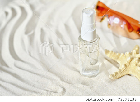 moisturizing gel for dry skin and after sun nourishing care. summer skin treatment. bottle of transparent gel on a sandy beach with starfish and glasses. moisturizing gel for dry skin and after sun nourishing care. summer skin treatment. bottle of transparent gel on a sandy beach with starfish and glasses. 75379135