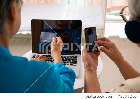 Two Asian senoir woman check online shopping and using credit card payment Two Asian senoir woman check online shopping and using credit card payment 75379216