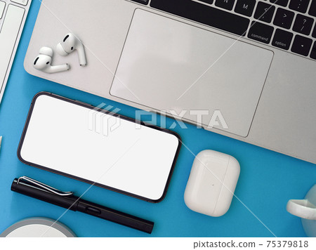 Creative flat lay workspace with smartphone, laptop, earphone and supplies on light blue background Creative flat lay workspace with smartphone, laptop, earphone and supplies on light blue background 75379818