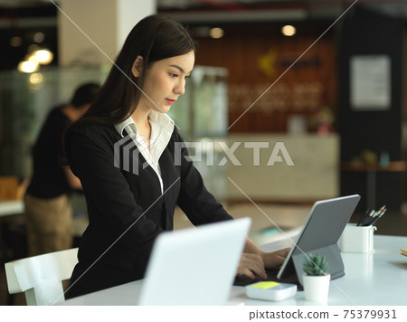 Businesswoman concentrating on her work with digital tablet in officer room 75379931