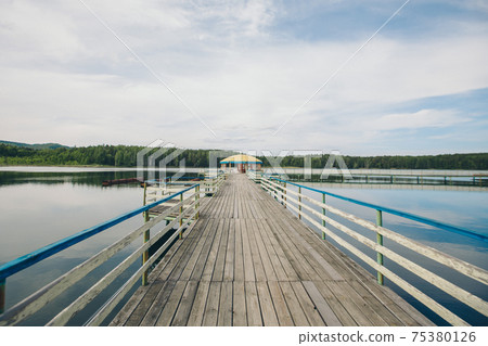 fishing bridge by the river. docks for boats on the lake. water and transport 75380126