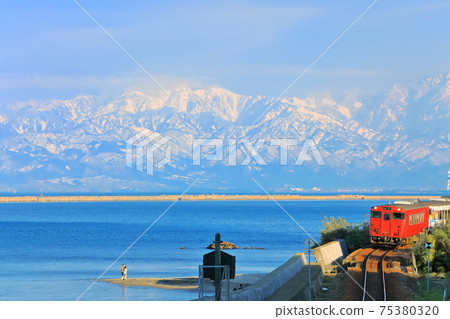 [Toyama Prefecture] Tateyama mountain range and train on the Amaharashi coast under fine weather 75380320