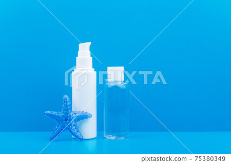 Face cream or scrub and skin lotion with star fish against blue background with copy space. Concept of sea cosmetics Face cream or scrub and skin lotion with star fish against blue background with copy space. Concept of sea cosmetics 75380349