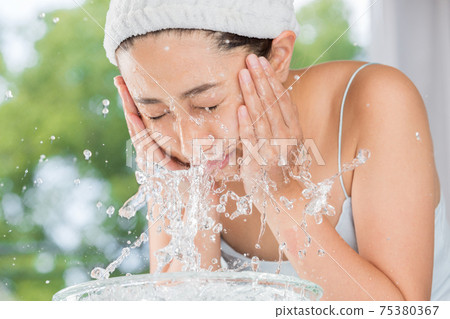 Women washing their face 75380367