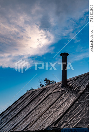 Old roof of an old Russian bathhouse, covered with roofing felt. Rural scene 75381865