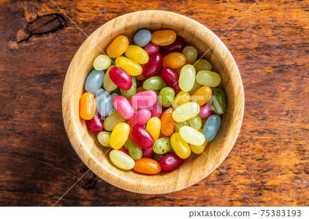 Sweet colorful jelly beans in wooden bowl. 75383193