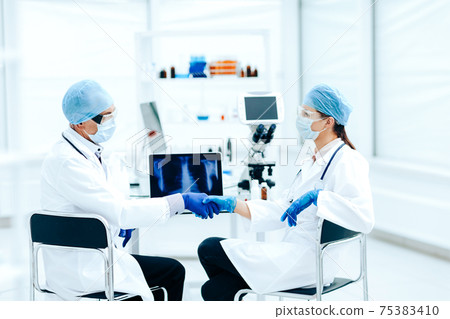 close up. medical colleagues shaking hands with each other . 75383410