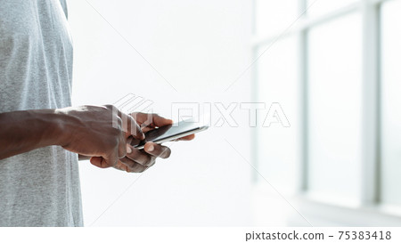 close up. young man typing SMS on his smartphone close up. young man typing SMS on his smartphone 75383418
