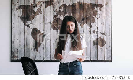 Woman collecting documents for report in modern office Woman collecting documents for report in modern office 75385808