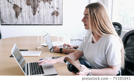 Portrait of blond woman using laptop in modern office 75385841