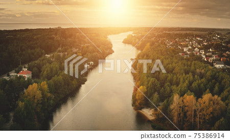 Sunset river aerial. Nobody nature landscape. Cottages at cityscape street. Urban building at shore 75386914