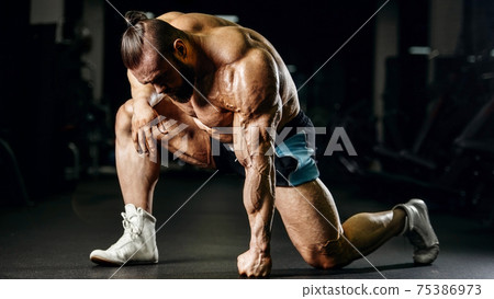 Brutal strong bodybuilder athletic men pumping up muscles with dumbbells 75386973