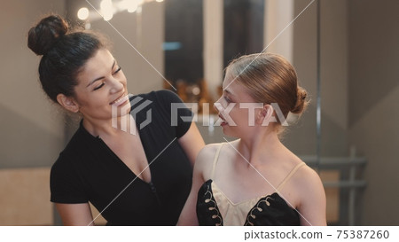 Teacher and young ballerina looking at each other and smiling 75387260