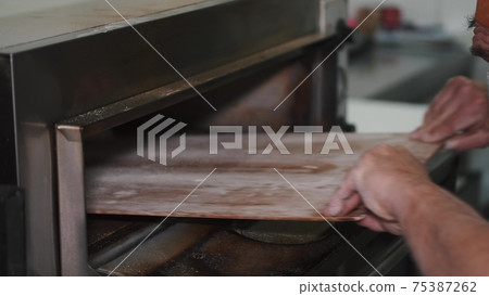 Chef putting tray of bread in industrial oven 4k Chef putting tray of bread in industrial oven 4k 75387262