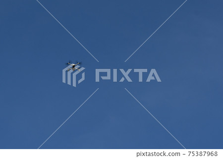 Quadrocopter on a background of blue sky. Quadrocopter on a background of blue sky. 75387968