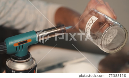 Man sticking the crative sticker on a hand-made glass in a workshop 75388138