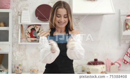 Pretty European woman having fun with flour in kitchen 75388408