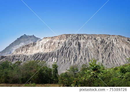 Environmantal impact of quarrying shown soil erosion from mountain. Environmantal impact of quarrying shown soil erosion from mountain. 75389726