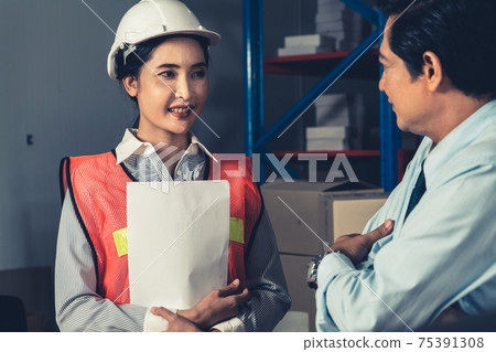 Warehouse manager and worker working in the storehouse 75391308
