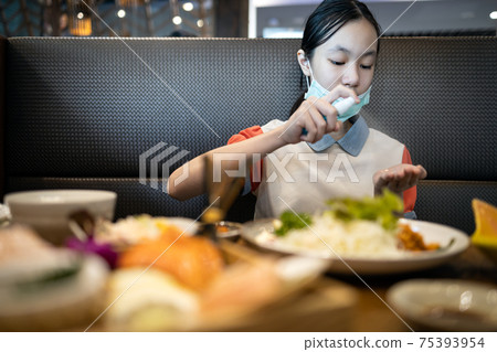 Asian schoolgirl wash hands with alcohol antiseptic to disinfect,female spraying disinfectant against Coronavirus,kill germs on her hand cleaning before eat food at restaurant during COVID-19 pandemic Asian schoolgirl wash hands with alcohol antiseptic to disinfect,female spraying disinfectant against Coronavirus,kill germs on her hand cleaning before eat food at restaurant during COVID-19 pandemic 75393954