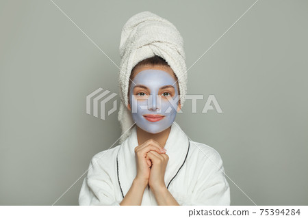 Cute spa woman in cosmetic face mask portrait. Facial treatment and skin care concept 75394284