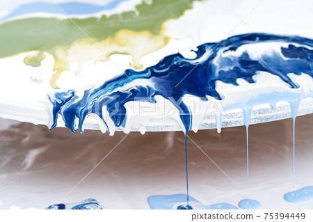 The process of creating a painting using fluid art technique. 75394449