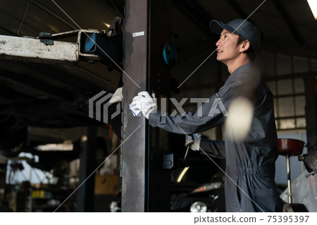 Auto mechanic working in a factory 75395397