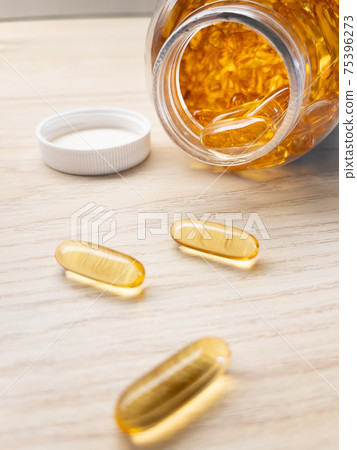 Yellow pills in drug bottle Yellow pills in drug bottle 75396273