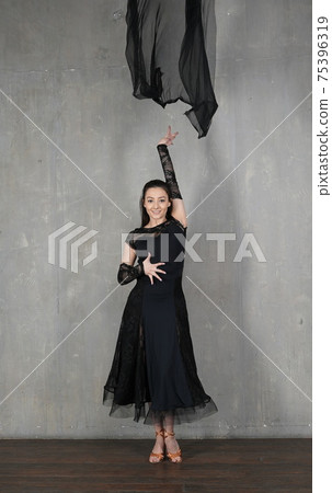 Woman dancer in motion with a cloth against the wall 75396319
