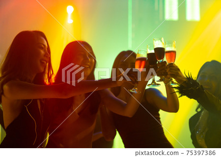 Silhouette image of people dance in disco night club to music from DJ on stage Silhouette image of people dance in disco night club to music from DJ on stage 75397386