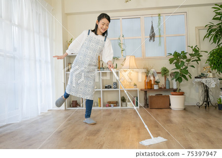 清潔：一位年輕女子，跳舞時戴著微笑的地板刮水器 75397947