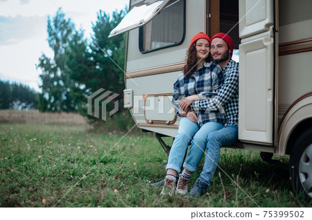 Couple spending time together near trailer home. Traveling with motor home. 75399502