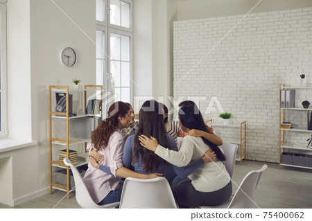 Young women sitting in circle in group meeting, talking and supporting each other Young women sitting in circle in group meeting, talking and supporting each other 75400062