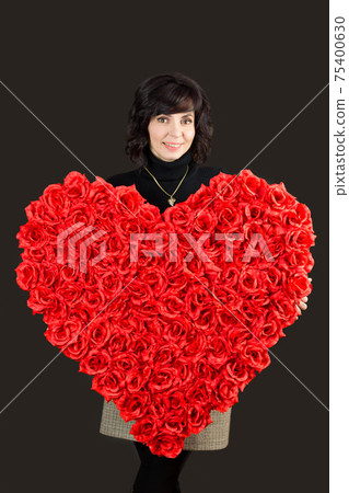 Woman with a padark for Valentine's day, a large bouquet of roses heart 75400630