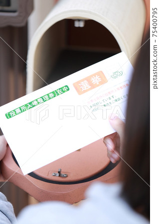 A woman's hand taking an election envelope from her mailbox A woman's hand taking an election envelope from her mailbox 75400795