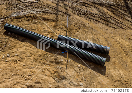 PVC tubes plastic pipes stacked in rows at construction site on reconstruction of the city drain system 75402178