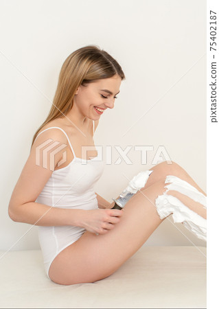 Woman shaving legs with knife Woman shaving legs with knife 75402187