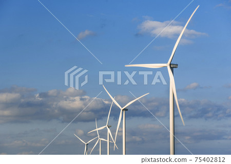 Windmills on a background of blue sky with clouds. Wind energy. Alternative energy. Windmills on a background of blue sky with clouds. Wind energy. Alternative energy. 75402812