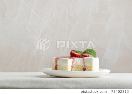 Delicious cheesecake with fresh strawberries and mint on white plate. Side view Delicious cheesecake with fresh strawberries and mint on white plate. Side view 75402813