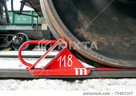 Brake shoe of rail wheel of train on the rail. Close-up 75403107