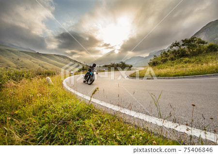 Motorcycle driver riding on mountain highway Motorcycle driver riding on mountain highway 75406846
