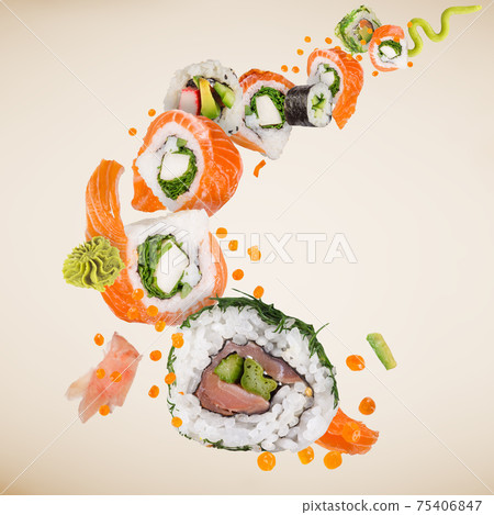 Sushi pieces placed between chopsticks, separated on white background. 75406847