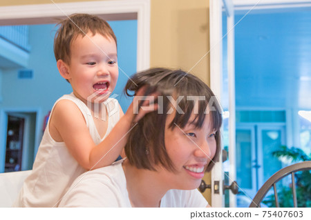 Happy Mixed Race Chinese and Caucasian Boy Having Fun with Chinese Mother Inside House Happy Mixed Race Chinese and Caucasian Boy Having Fun with Chinese Mother Inside House 75407603