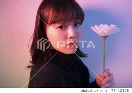 Woman with flowers in color light Woman with flowers in color light 75412108