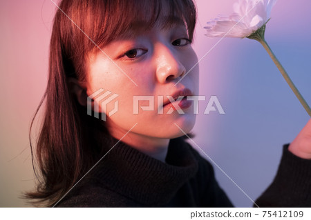 Woman with flowers in color light 75412109