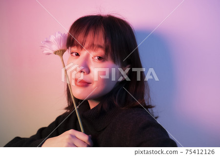 Woman with flowers in color light Woman with flowers in color light 75412126